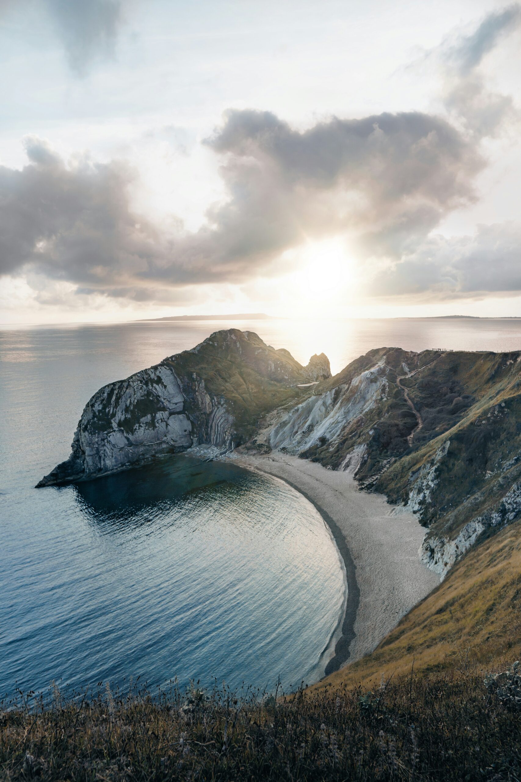 Sun rise over the sea, with cliffs and bay in the foreground
