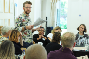 A picture of Caleb Parkin speaking at a workshop at the RENEW x BookTrust Biodiversity Storytelling Summit.