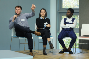 An image of Will Bugg, Anqi Liu and Patrick Oko Quaye discussing their research at the Biodiversity Parliament 2023.