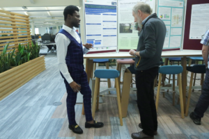 An image of Patrick Oko Quay and Peter White discussing PhD posters.