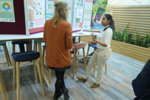 An image of Jo Furtado and Devmini Bandara discuss their PhD posters.