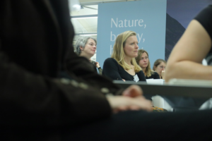 An image of Jo Furtado listening to a research present their work.